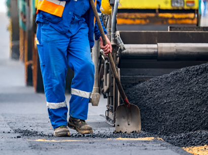 Close view on the workers and the asphalting machines